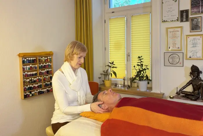 Frau wendet Methoden der Access Bars an - sanfte Anwendung, die eine leichte Berührung am Kopf einsetzt,