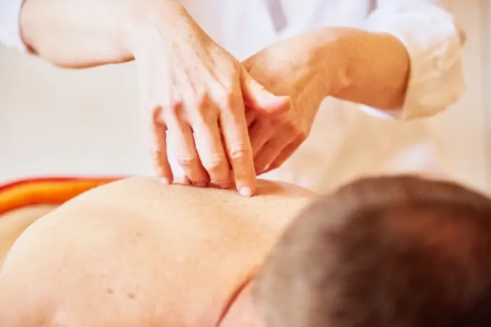 verschiedene ätherische Öle werden entlang der Wirbelsäule aufgetropft und sanft einmassiert, um das Wohlbefinden zu steigern