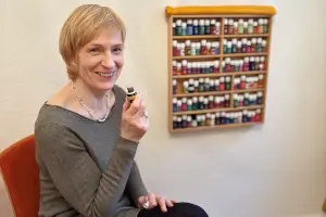 Frau schnuppert an einem Fläschchen mit ätherischem Öl