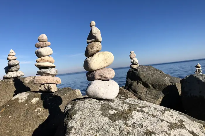 Steintürme am Strand spiegeln die unterschiedlichen Projekte im Führungsalltag wieder